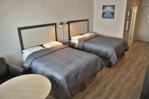 罗贝瓦勒卡斯蒂尔汽车旅馆的酒店客房设有两张床和一张桌子。