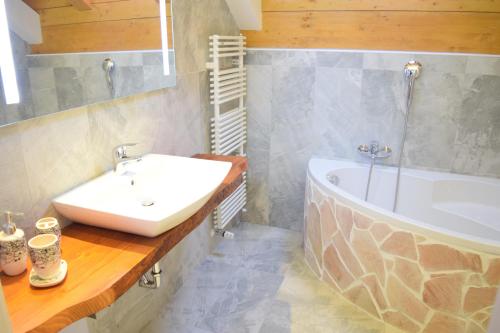 塔尔维西奥Casa Vacanza CADORNA RESIDENCE的浴室配有盥洗盆和浴缸。