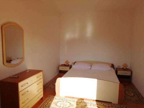 扎达尔伊万卡公寓的一间卧室配有一张床、梳妆台和镜子