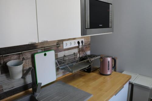 塞格德Petofi Apartman的厨房配有带微波炉的柜台和桌子。