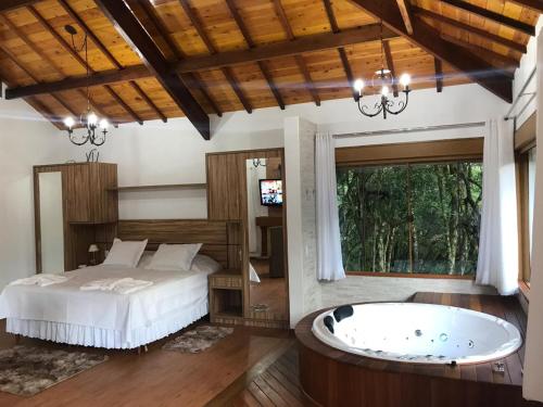 蒙特韦尔迪Chalés Recanto das Montanhas的一间卧室配有一张床和浴缸