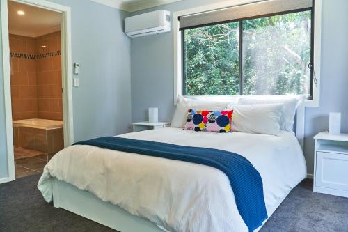 马莱尼Treetops Haven的一间卧室设有一张大床和一个窗户。