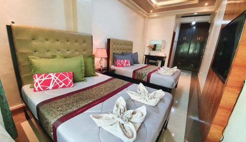 TayabasPiscana Resort的两张位于酒店客房的床,配有毛巾