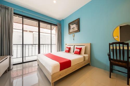 华欣OYO 314 The Space Huahin的一间拥有蓝色墙壁的卧室和一张带红色枕头的床