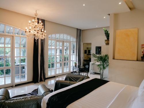 塞米亚克Casa Artista By Kresna Hospitality的一间卧室配有一张大床和一个吊灯。