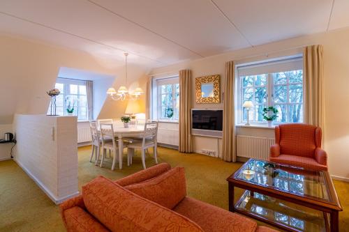 欧登塞Hotel Knudsens Gaard的客厅配有沙发和桌子