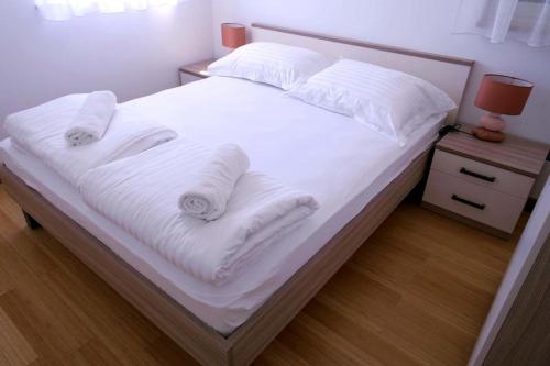 苏提万Dalmatino - apartment 6的一张带白色床单和枕头的床