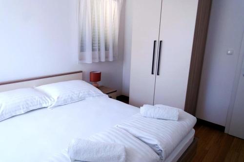 苏提万Dalmatino - apartment 6的一间卧室配有两张带白色床单的床和冰箱