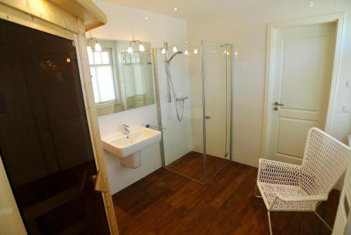 欧巴德伍斯图Haus STRANDHAFER WF-06 (links)的一间带水槽、淋浴和镜子的浴室