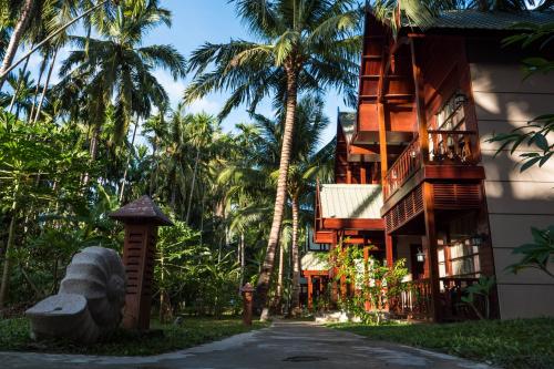尼尔岛海舍尔尼尔度假村的一条街道旁的棕榈树建筑