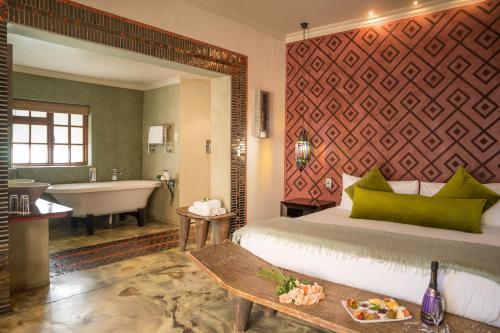伊丽莎白港Singa Lodge - Lion Roars Hotels & Lodges的一间卧室配有一张床、一个浴缸和一个水槽