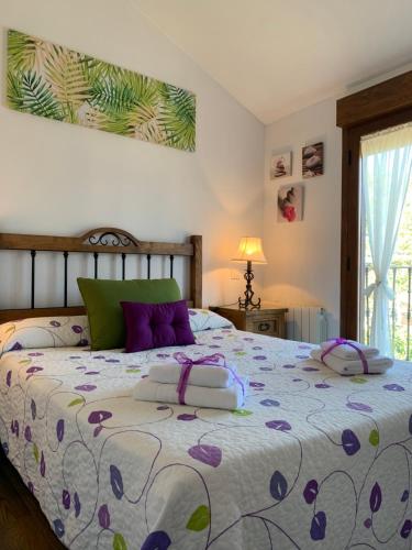 Ortigosa del MonteLa Casa De La Abuela的一间卧室配有一张带紫色枕头的大床