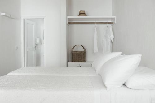 米克诺斯城特瑞马里亚酒店的白色卧室配有带白色枕头的床