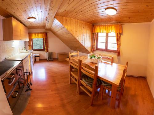 GoreljekDigital Detox Chalet Pokljuka的厨房以及带木桌的用餐室。