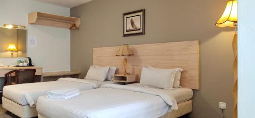 马六甲马六甲普瑞玛酒店的配有白色床单的酒店客房内的两张床