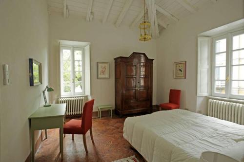 切尔诺比奥Bilocale nel Parco di Villa Erba的一间卧室配有一张床、一张桌子和两把椅子