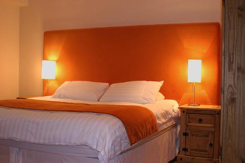 斯特灵Kingsview Apartment的一间卧室配有一张带橙色床头板的大床