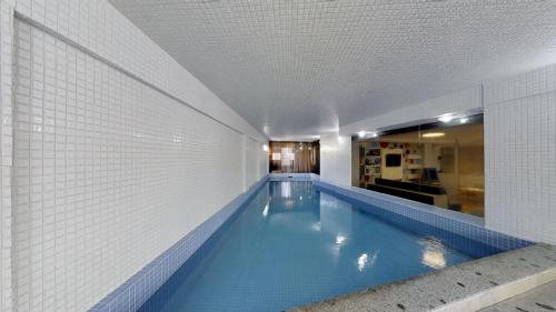 巴拉奈里奥-坎布里乌Camboriú Praia Hotel的一座带瓷砖墙的建筑中的游泳池