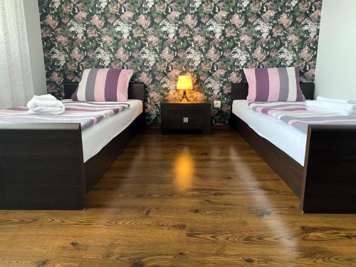 奥洛穆茨格洛丽亚宾馆的客房设有两张床和一张带台灯的桌子。