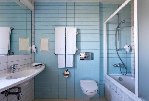 克莱佩达Green Park Hotel Klaipeda的蓝色的浴室设有卫生间和水槽