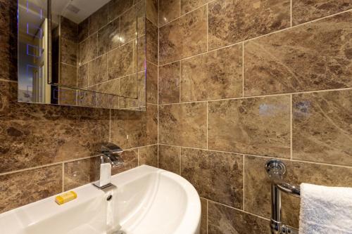 阿尔斯通阿尔斯通之家酒店的一间带水槽、浴缸和镜子的浴室