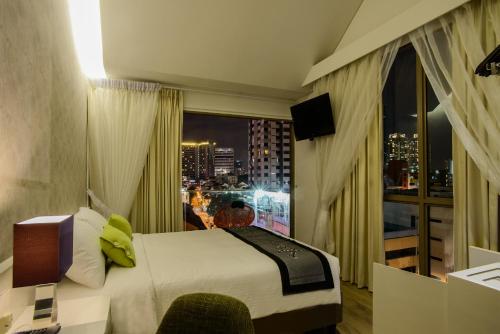 新加坡J8 Hotel的酒店客房设有一张床和一个大窗户