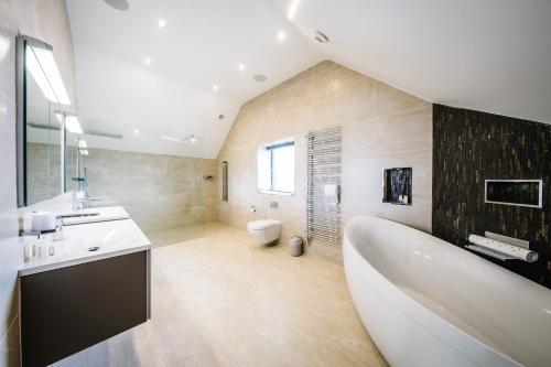 肯德尔Carus House @ Carus Green的带浴缸、盥洗盆和卫生间的浴室