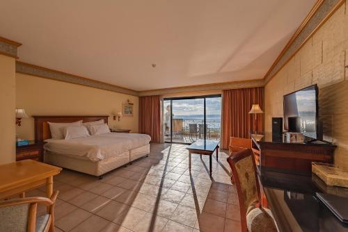 艾因西莱姆戈佐大酒店的一间卧室配有一张床、一张书桌和一台电视