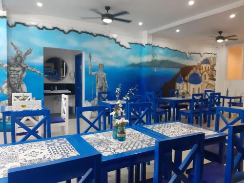 公主港Skytel Palawan的一间设有蓝色桌子和壁画的用餐室