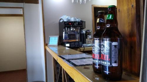 埃尔卡拉法特Altos de Soberana的两瓶啤酒坐在一个房间里的一个柜台上