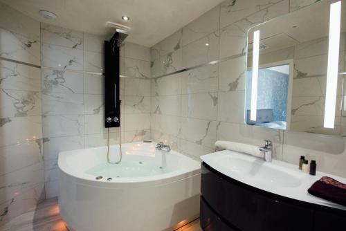 拉波勒Amirauté的带浴缸、水槽和镜子的浴室
