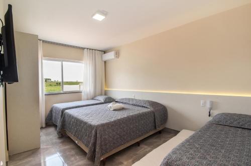 佩尼亚Pousada Espindola的酒店客房设有两张床和窗户。