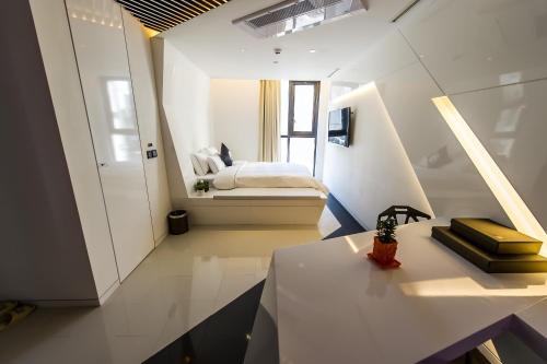 首尔钟路区设计酒店的白色的小房间,配有床和桌子