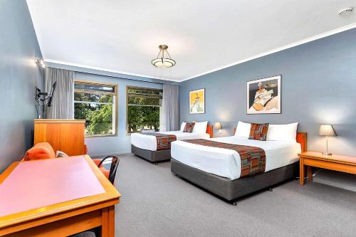 阿德莱德Quality Inn O'Connell的酒店客房配有两张床和一张书桌