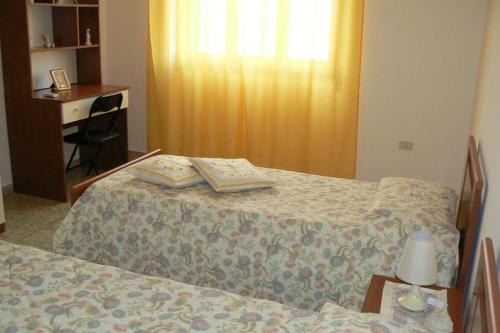 卡尔博尼亚Mariangela's Home的一间卧室配有一张床、一张桌子和一张带台灯的桌子