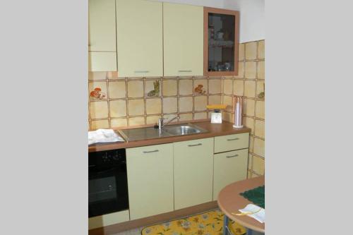 卡尔博尼亚Mariangela's Home的厨房配有白色橱柜、水槽和桌子