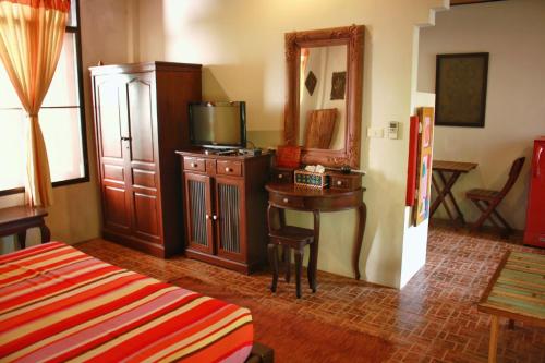 拉迈Varinda Resort的一间卧室配有一张床和一张桌子及一台电视