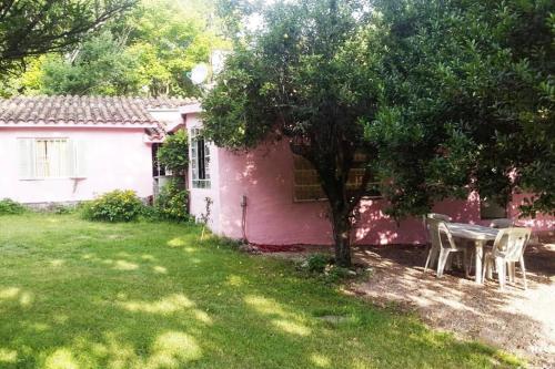 萨尔西普埃德斯Hamacas Serranas的一座粉红色的房子,在院子里配有桌椅