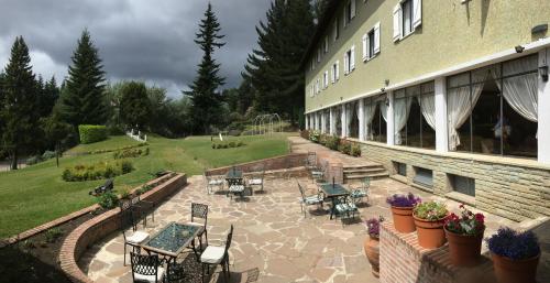 圣卡洛斯-德巴里洛切泛美大酒店的一座配有桌椅的建筑的庭院
