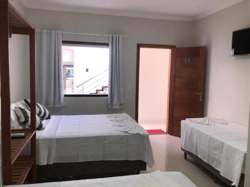 塞古罗港Pousada Veleiro的酒店客房设有两张床和窗户。