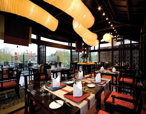 丽江丽江悦榕庄的餐厅设有桌椅和大窗户。