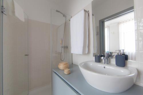 波尔图卡里祖城市休闲公寓的白色的浴室设有水槽和淋浴。