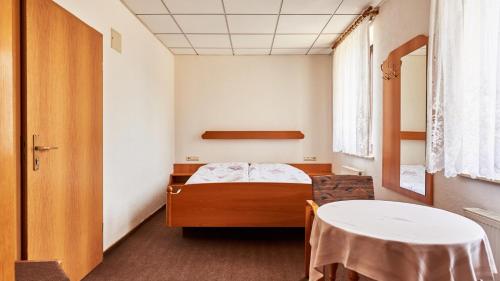 诺伊豪森Pension Grenzhof的小房间设有一张床和一张桌子