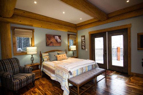 戈尔登Golden Acres Mountain Lodge的一间卧室配有一张床、一把椅子和窗户。