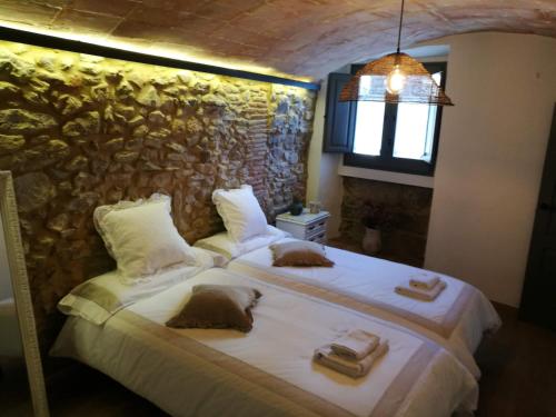 La PeraCan Puig de la Pera的一间卧室设有两张床和石墙