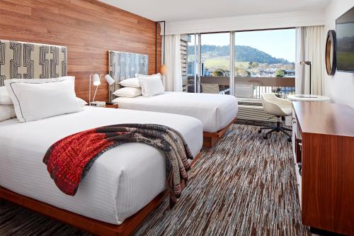 卡梅尔Carmel Mission Inn的酒店客房配有两张床和一张书桌