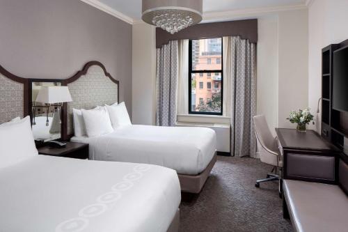 纽约Park South Hotel, part of JdV by Hyatt的酒店客房设有两张床、一张桌子和一台电视。