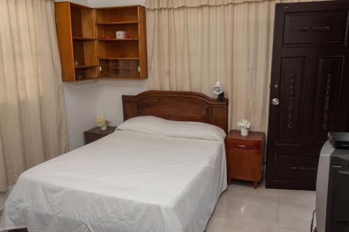 基布多Apartamento amoblado的一间卧室配有一张带白色床单的床和橱柜。