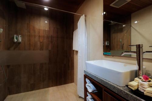 库塔库塔巴厘岛温纳别墅假日酒店的浴室设有白色水槽和镜子