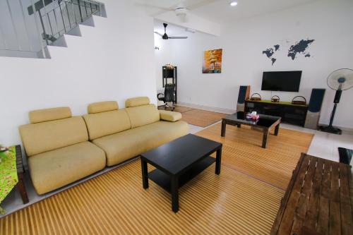 乌鲁地南Kz-COZY Homestay@D.Cemerlang的客厅配有沙发和桌子